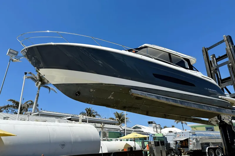  Yacht Photos Pics 2023 Regal 36 XO boat lifted on a forklift under a clear blue sky.