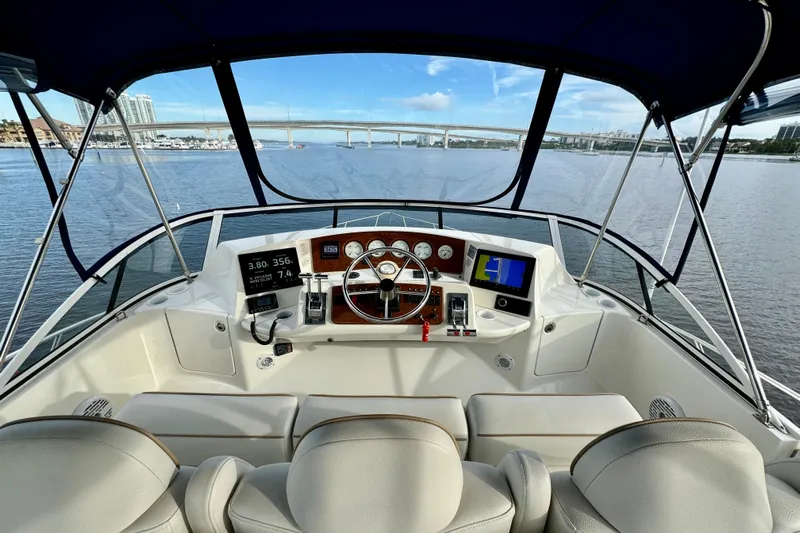 Yacht Photos Pics 2006 Silverton 38 Sport Bridge helm with modern navigation equipment, overlooking a scenic waterway.