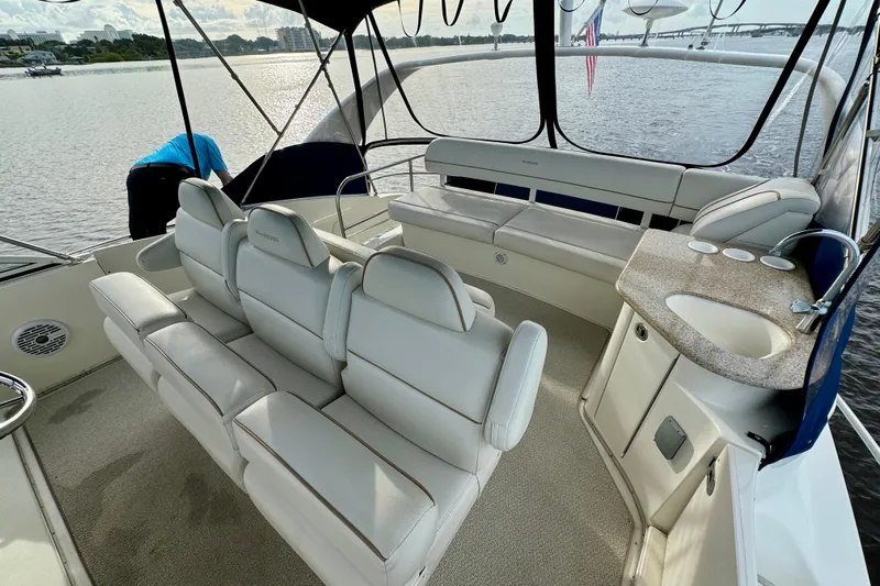  Yacht Photos Pics 2006 Silverton 38 Sport Bridge interior with white seating and kitchenette on a calm waterway.