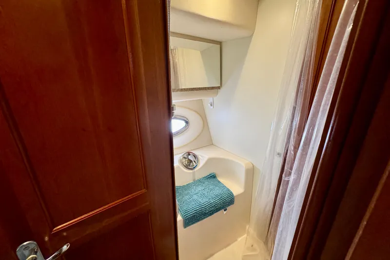  Yacht Photos Pics 2006 Silverton 38 Sport Bridge bathroom with sink, mirror, and porthole window.