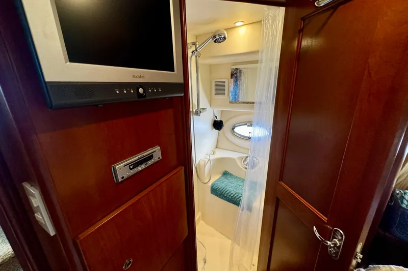  Yacht Photos Pics 2006 Silverton 38 Sport Bridge bathroom with shower, TV, and wooden cabinetry.