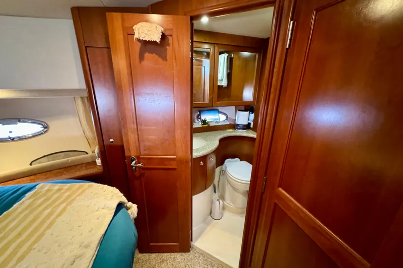  Yacht Photos Pics 2006 Silverton 38 Sport Bridge interior with wooden cabinetry and compact bathroom.