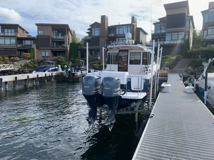  Yacht Photos Pics 2018 Cutwater C-302 Coupe docked at a marina with modern waterfront homes.