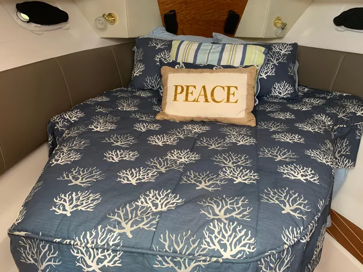  Yacht Photos Pics Cozy 2018 Cutwater C-302 Coupe cabin with coral-patterned bedding and "Peace" pillow.