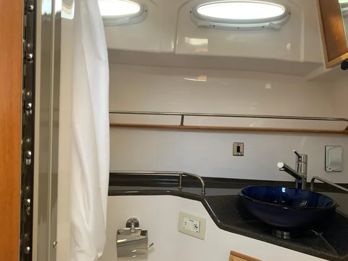  Yacht Photos Pics 2018 Cutwater C-302 Coupe bathroom with modern sink and porthole windows.