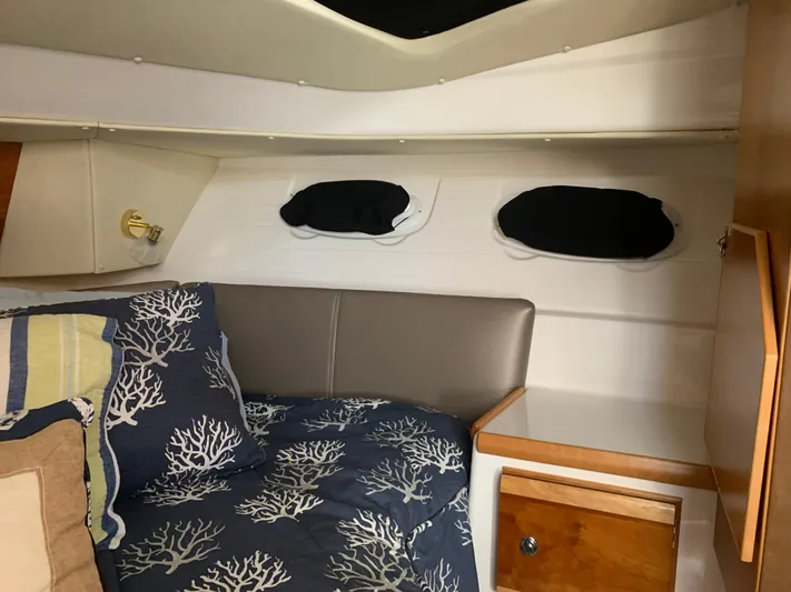  Yacht Photos Pics 2018 Cutwater C-302 Coupe cabin interior with cozy bedding and wooden cabinetry.
