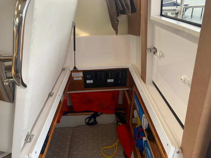  Yacht Photos Pics 2018 Cutwater C-302 Coupe cabin storage area with safety equipment and control panels.