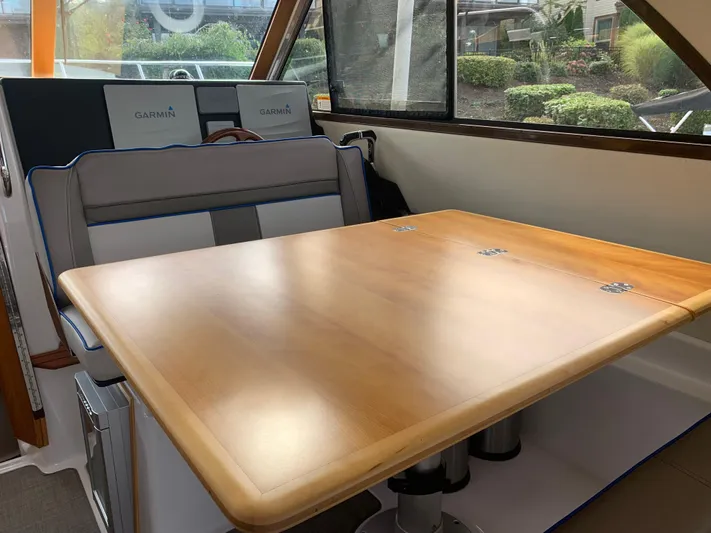  Yacht Photos Pics Interior of 2018 Cutwater C-302 Coupe with wooden table and cushioned seating.