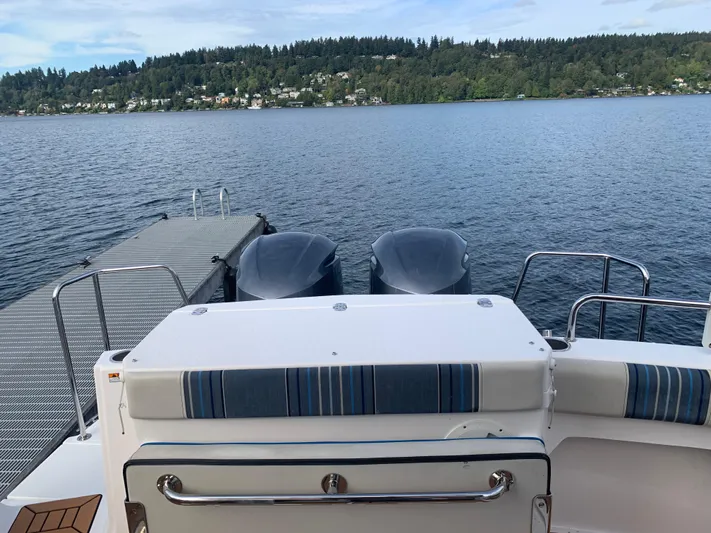  Yacht Photos Pics 2018 Cutwater C-302 Coupe at dock, overlooking serene lake and forested shoreline.