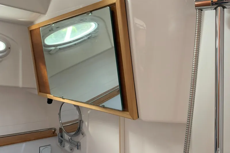  Yacht Photos Pics 2018 Cutwater C-302 Coupe bathroom interior with mirror and porthole window.