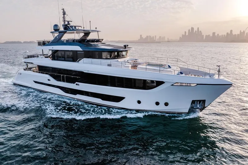  Yacht Photos Pics Luxurious 2027 Majesty 112 Terrace yacht cruising near a city skyline at sunset.