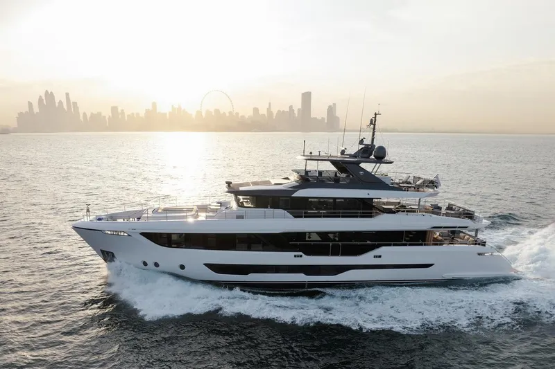  Yacht Photos Pics Luxurious 2027 Majesty 112 Terrace yacht cruising near a city skyline at sunset.