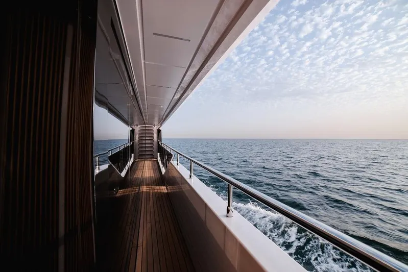  Yacht Photos Pics Majesty 112 Terrace yacht deck overlooking ocean, 2027 model, under a partly cloudy sky.