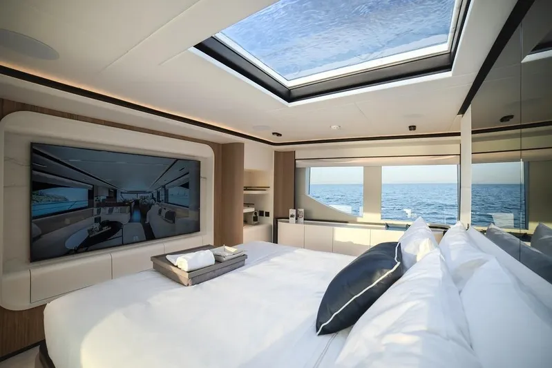  Yacht Photos Pics Luxurious bedroom interior of 2027 Majesty 112 Terrace yacht with ocean view and skylight.