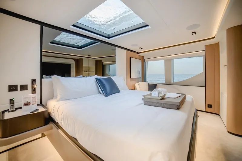  Yacht Photos Pics Luxurious bedroom interior of 2027 Majesty 112 Terrace yacht with ocean view and skylight.