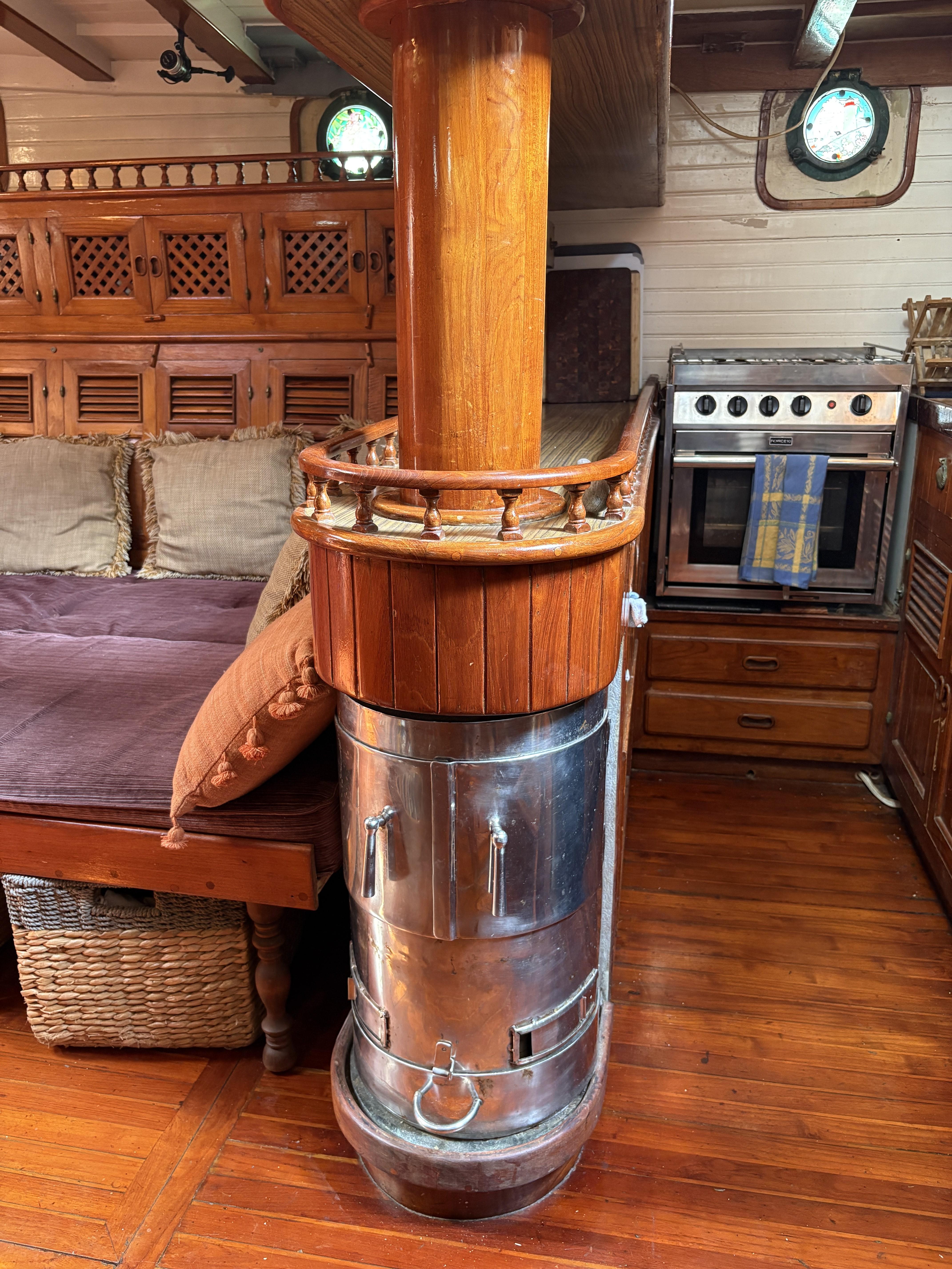 Vintage 1975 Formosa 51 yacht interior with wood stove and cozy furnishings.