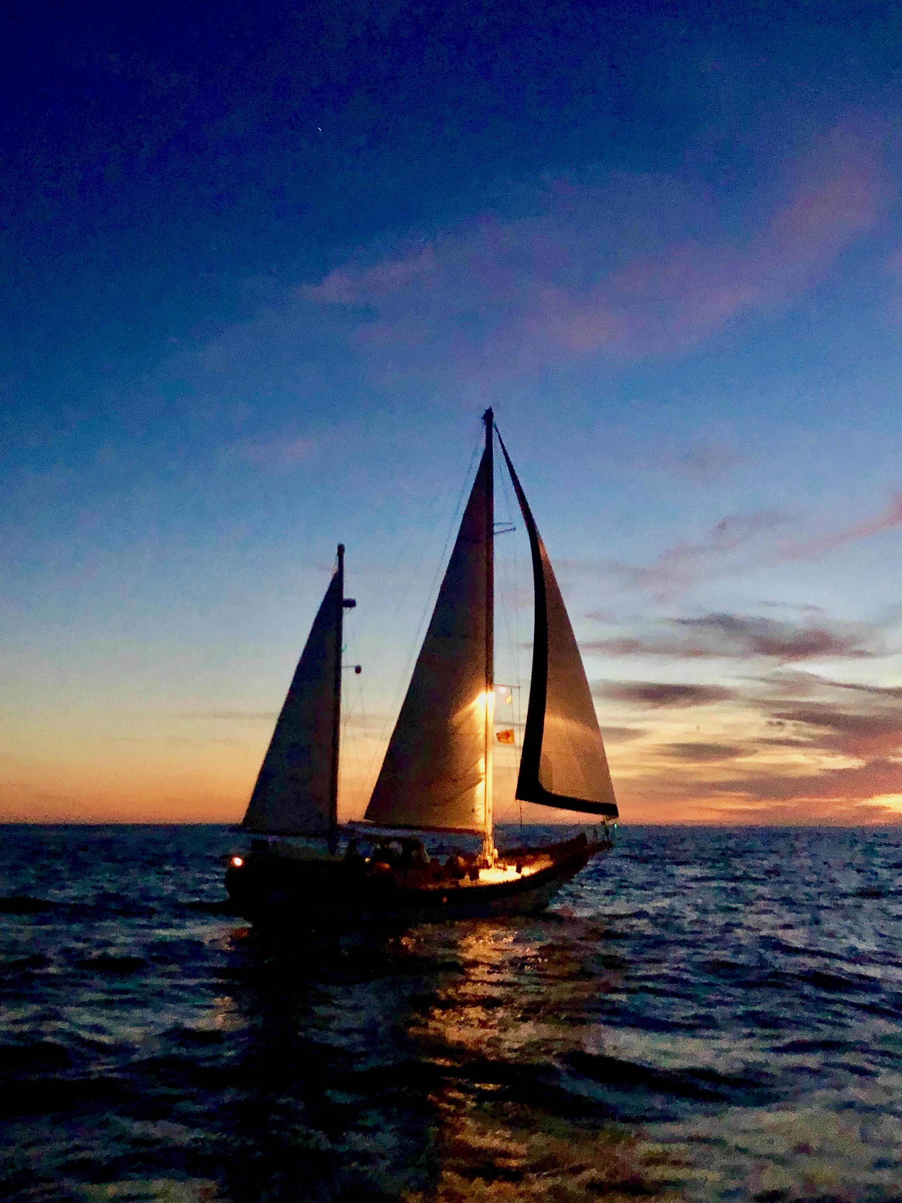 Sailing yacht Formosa 51 at sunset, 1975 model, silhouetted against a vibrant sky.