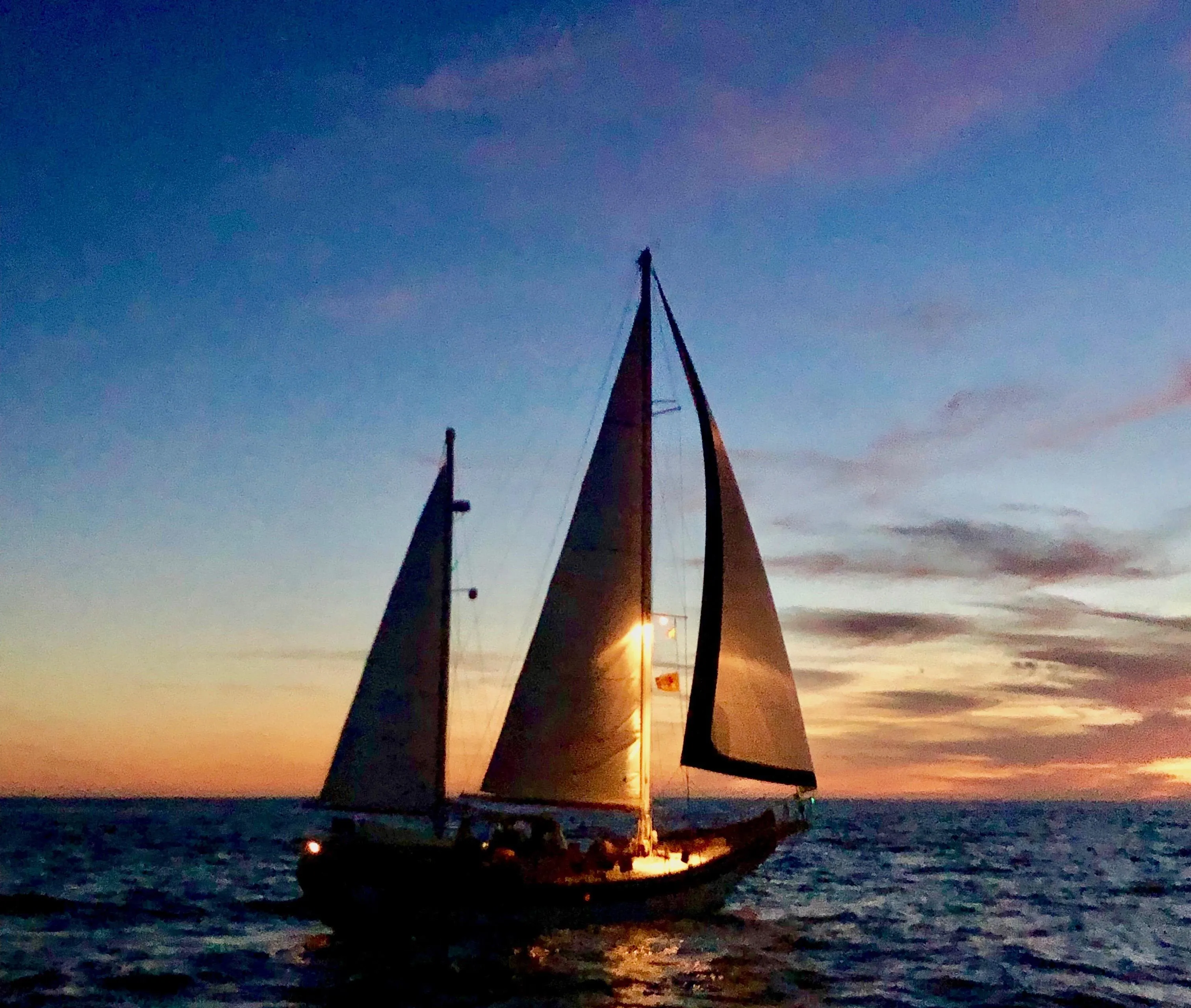 Sailing yacht Formosa 51 at sunset, 1975 model, silhouetted against a vibrant sky.