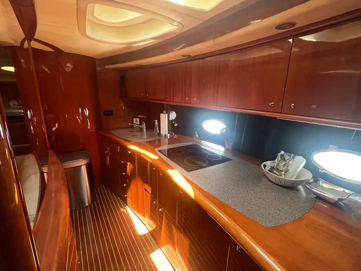  Yacht Photos Pics Luxurious kitchen interior of 2000 Sunseeker Predator 74 yacht with wooden cabinetry.