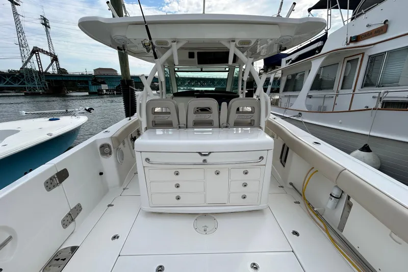  Yacht Photos Pics 2017 Boston Whaler 370 Outrage boat interior with seating and storage, docked by the water.