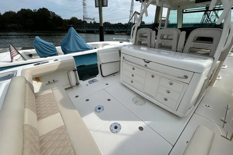  Yacht Photos Pics 2017 Boston Whaler 370 Outrage boat interior with seating and storage, docked by the water.