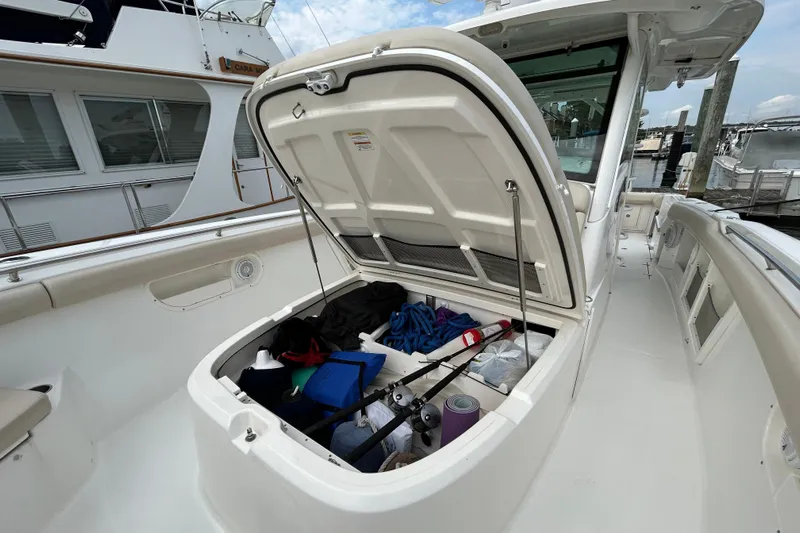  Yacht Photos Pics Open storage compartment on a 2017 Boston Whaler 370 Outrage boat, docked at a marina.