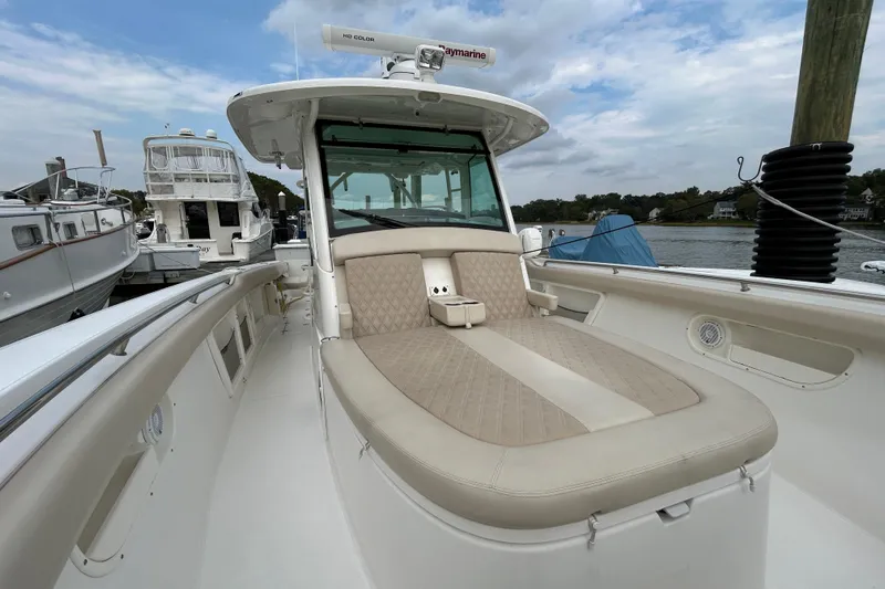  Yacht Photos Pics 2017 Boston Whaler 370 Outrage boat with cushioned seating, docked at a marina.