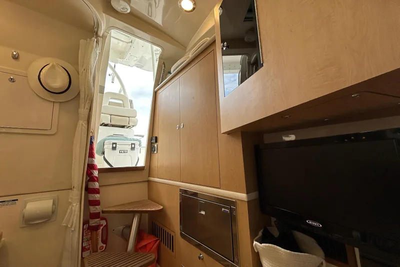  Yacht Photos Pics Interior of 2017 Boston Whaler 370 Outrage, featuring wooden cabinetry and a mounted TV.