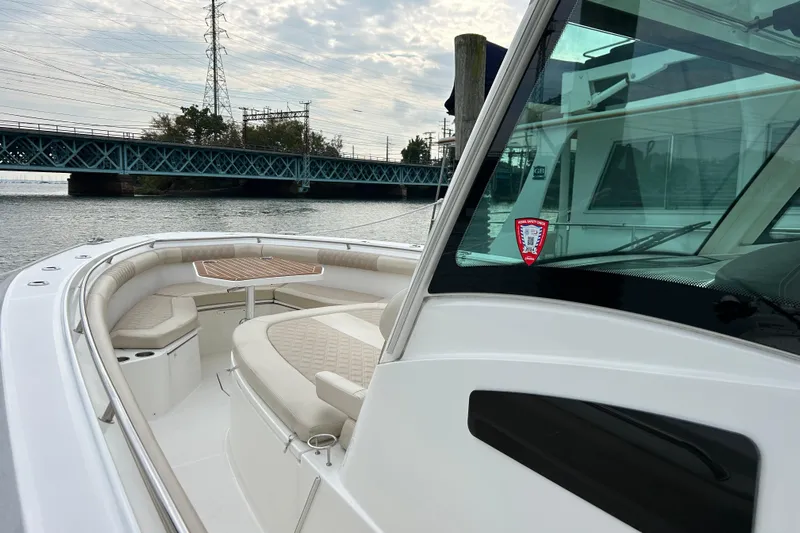  Yacht Photos Pics 2017 Boston Whaler 370 Outrage boat with seating, near a bridge on a cloudy day.