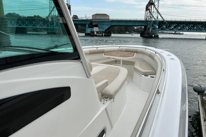  Yacht Photos Pics 2017 Boston Whaler 370 Outrage boat with seating, docked near a bridge.