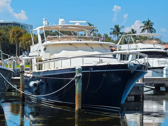 Brown Yacht Photos Pics 1989 Tollycraft 61 Pilothouse Motor Yacht docked in a sunny marina.