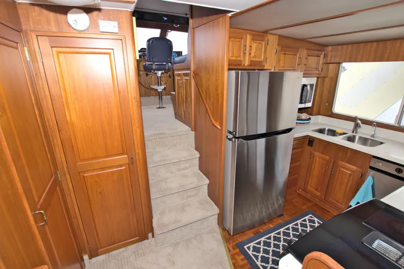 Brown Yacht Photos Pics Interior of 1989 Tollycraft 61 Pilothouse Motor Yacht with wood cabinetry and modern appliances.
