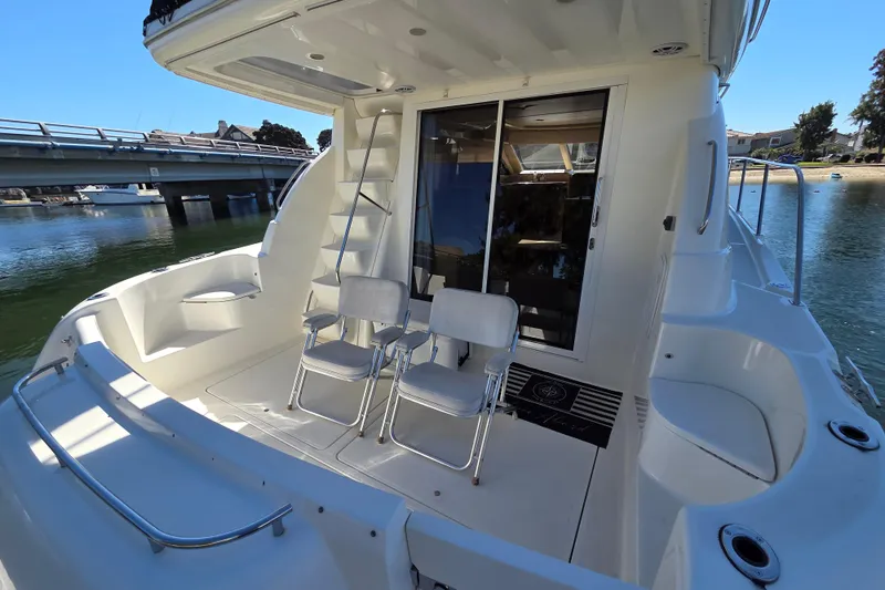 Soul Mates Yacht Photos Pics 2005 Meridian 411 Sedan yacht deck with chairs, near a bridge and waterfront.