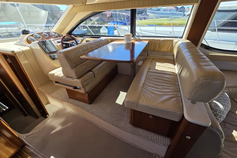 Soul Mates Yacht Photos Pics Luxurious interior of a 2005 Meridian 411 Sedan yacht with leather seating and wooden table.