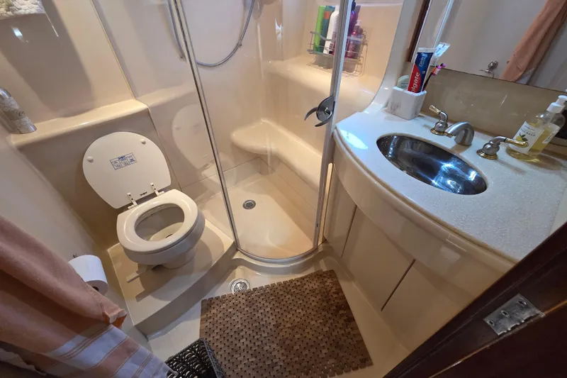 Soul Mates Yacht Photos Pics Bathroom interior of 2005 Meridian 411 Sedan yacht, featuring shower, toilet, and sink.