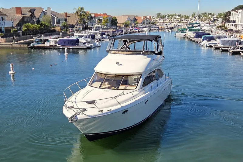 Soul Mates Yacht Photos Pics 2005 Meridian 411 Sedan yacht cruising in a marina with docked boats and waterfront homes.