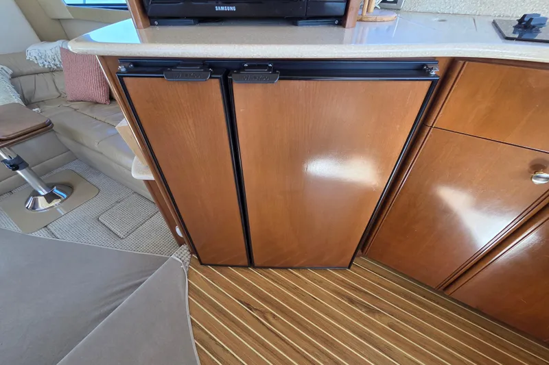 Soul Mates Yacht Photos Pics 2005 Meridian 411 Sedan interior with wooden cabinetry and compact refrigerator.