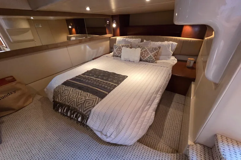 Soul Mates Yacht Photos Pics Luxurious bedroom interior of 2005 Meridian 411 Sedan yacht with cozy bedding and ambient lighting.