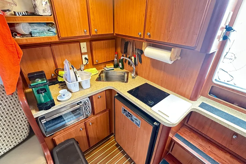 Yacht Photos Pics 2008 Luhrs 31 Hard Top IPS boat kitchen with wooden cabinets and modern appliances.