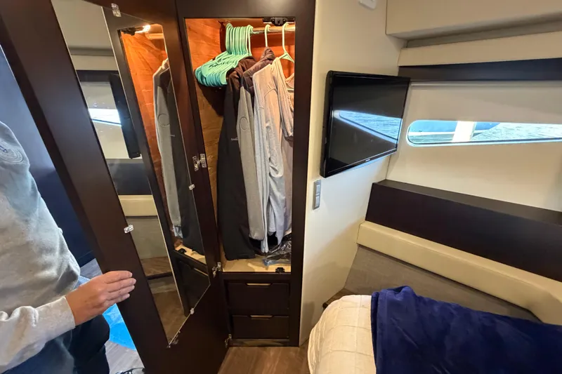 Dancing Queen Yacht Photos Pics Interior of 2019 Regal 42 Grande Coupe with wardrobe, TV, and bed.