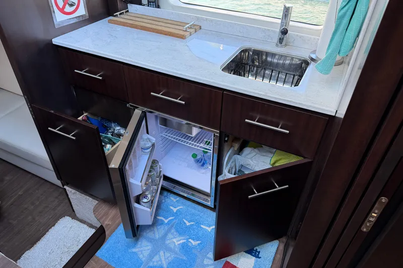 Dancing Queen Yacht Photos Pics Interior of 2019 Regal 42 Grande Coupe yacht kitchen with sink and open fridge.