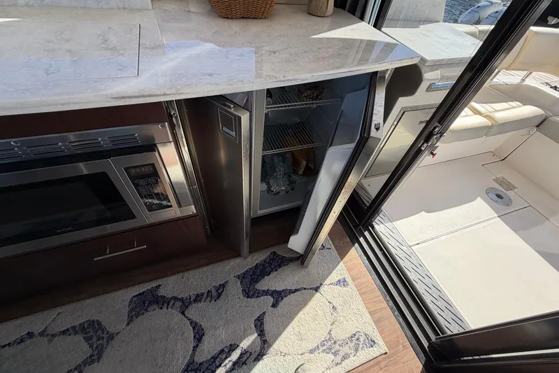 Dancing Queen Yacht Photos Pics 2019 Regal 42 Grande Coupe yacht interior with open fridge and microwave.