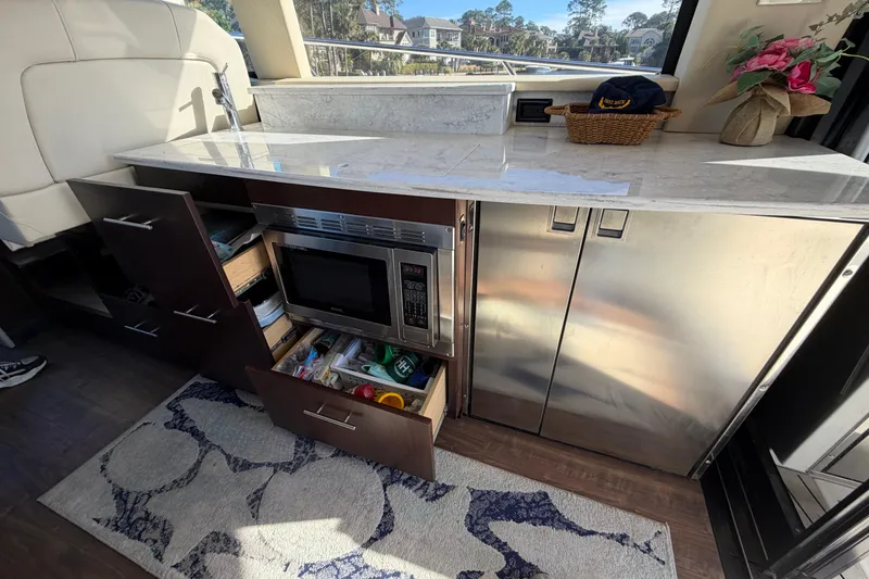 Dancing Queen Yacht Photos Pics 2019 Regal 42 Grande Coupe yacht kitchen with microwave, cabinets, and countertop.
