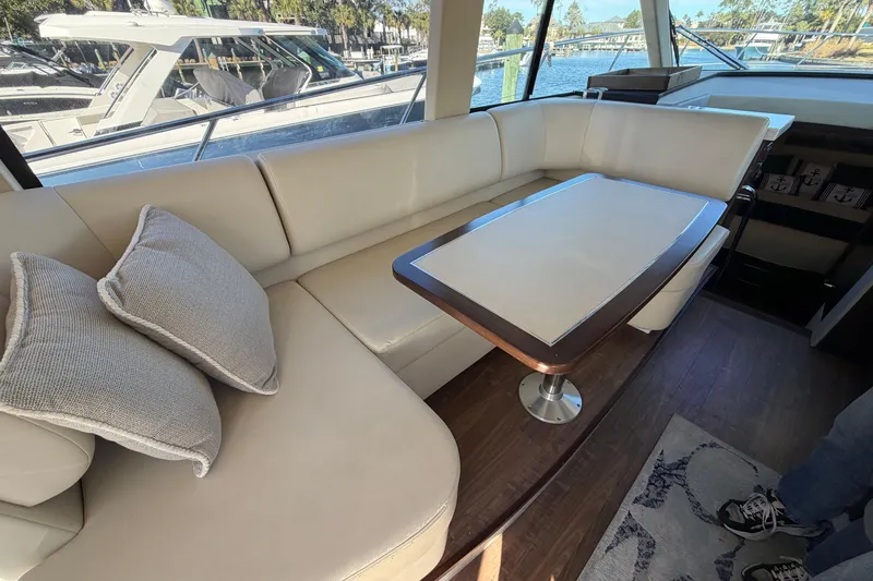 Dancing Queen Yacht Photos Pics Luxurious interior of 2019 Regal 42 Grande Coupe yacht with elegant seating and table.