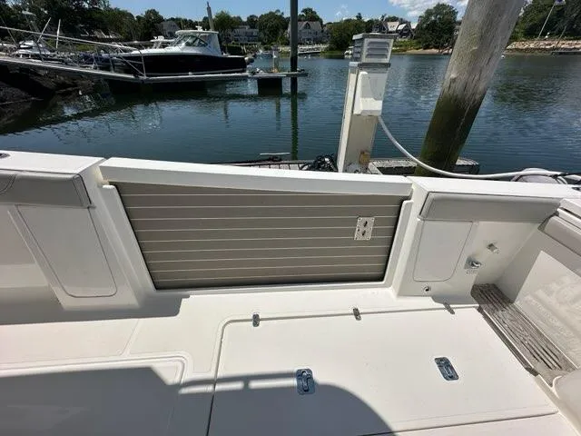Blue Liner Yacht Photos Pics 2021 Pursuit S 428 Sport boat docked at marina, showcasing deck and water view.