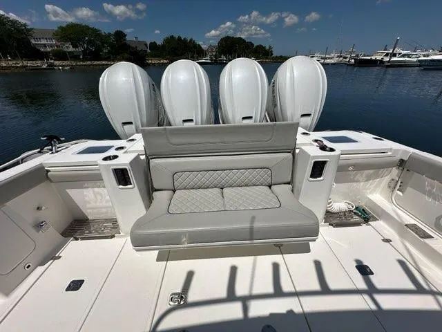 Blue Liner Yacht Photos Pics 2021 Pursuit S 428 Sport boat with quad engines and cushioned seating, docked by the water.