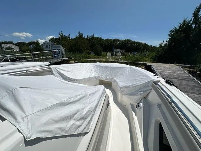 Blue Liner Yacht Photos Pics 2021 Pursuit S 428 Sport boat with cover on deck, docked outdoors.