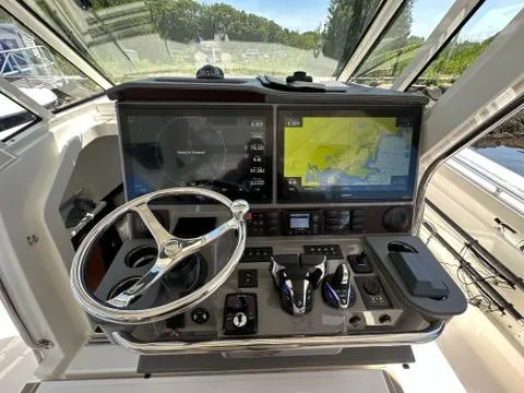 Blue Liner Yacht Photos Pics 2021 Pursuit S 428 Sport boat dashboard with navigation screens and steering wheel.