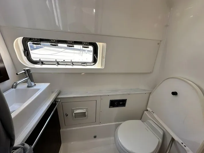 Blue Liner Yacht Photos Pics 2021 Pursuit S 428 Sport boat bathroom with sink, toilet, and window.