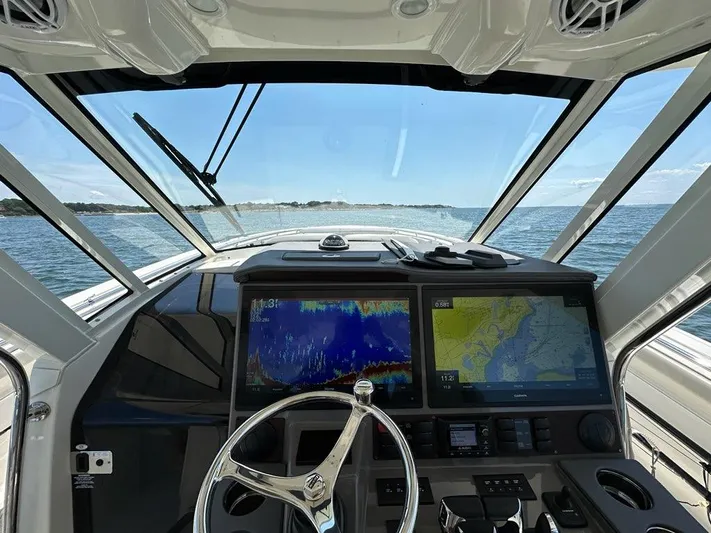 Blue Liner Yacht Photos Pics 2021 Pursuit S 428 Sport boat dashboard with navigation screens on open water.